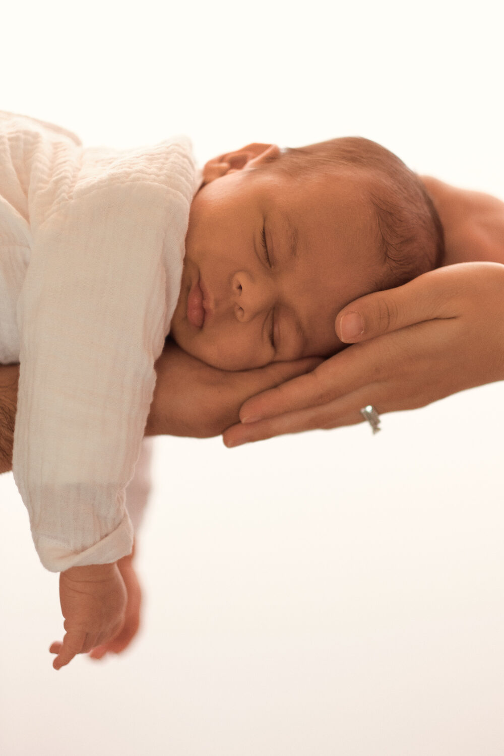 Newborn sleeping in parent's hands