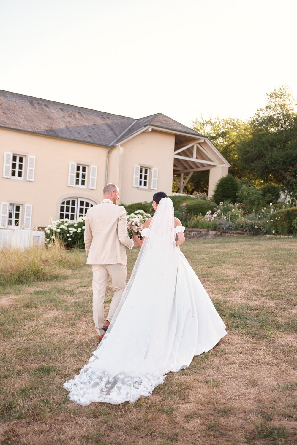 Bride and groom walking back to the house at Hazelnut House at golden hour