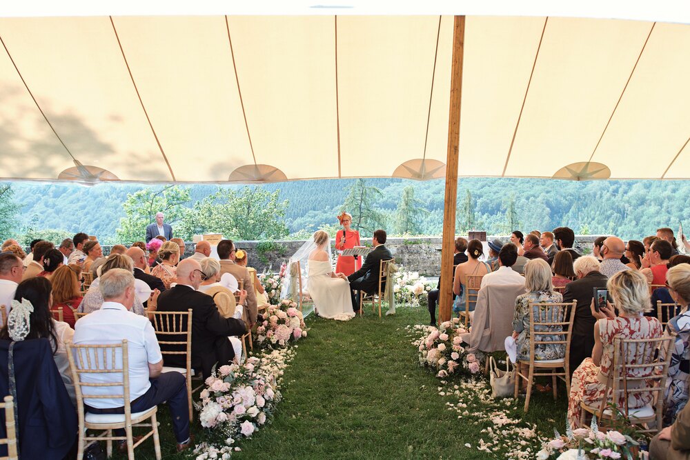 The ceremony tent on the lawn at Chateau de Mirwart, open to the Ardennes valley