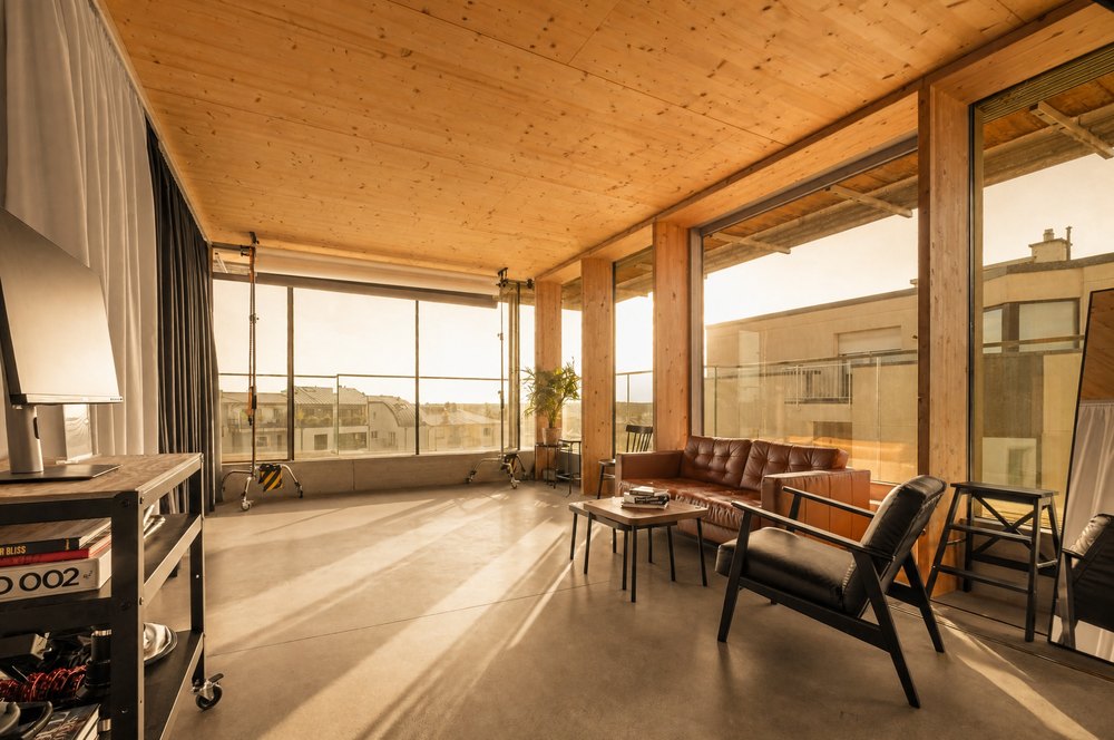 Our studio in Belair at golden hour: wooden ceiling, tall windows, a leather sofa and an armchair