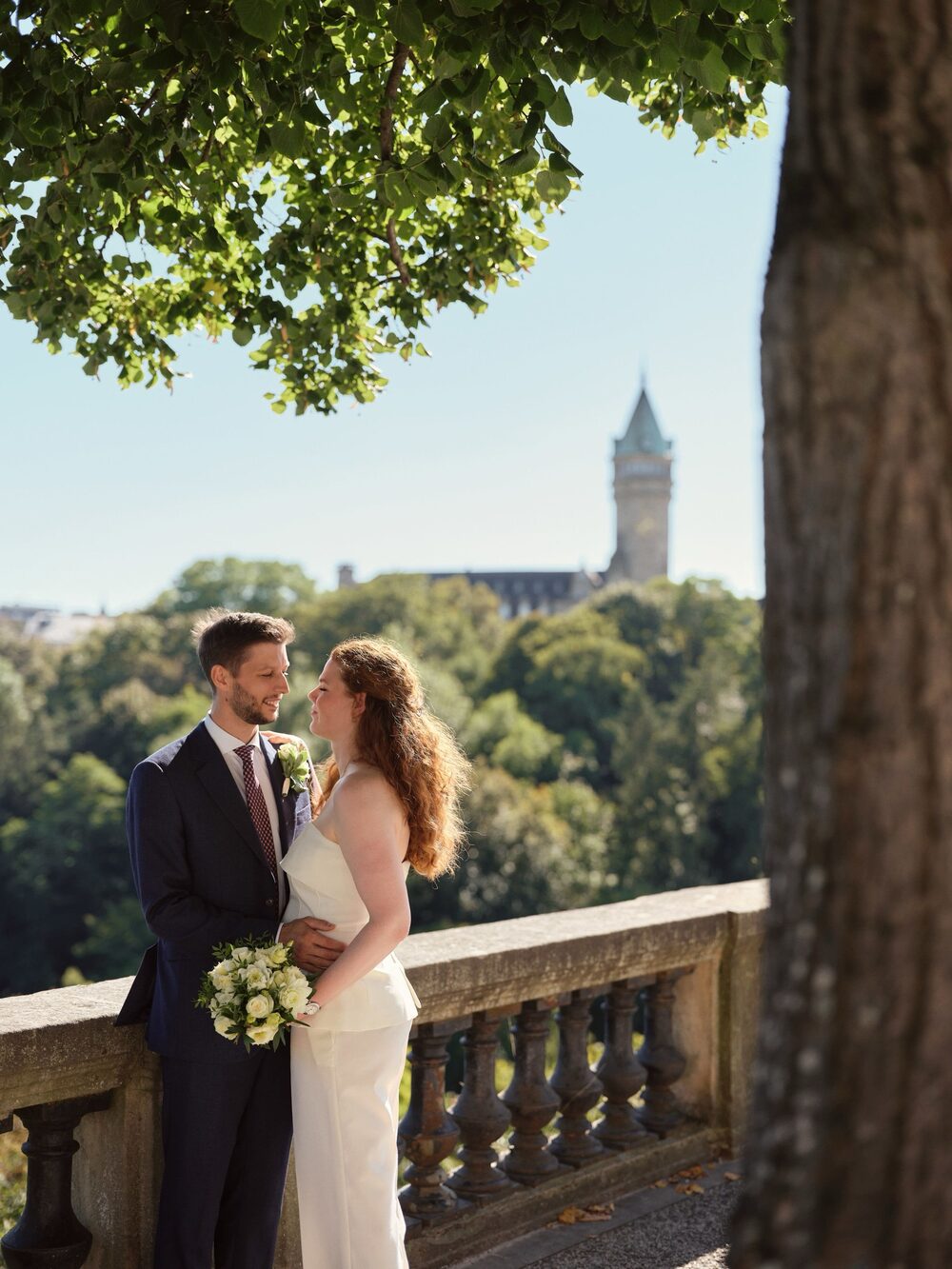 Couple kiss riverside — wide scenic Luxembourg